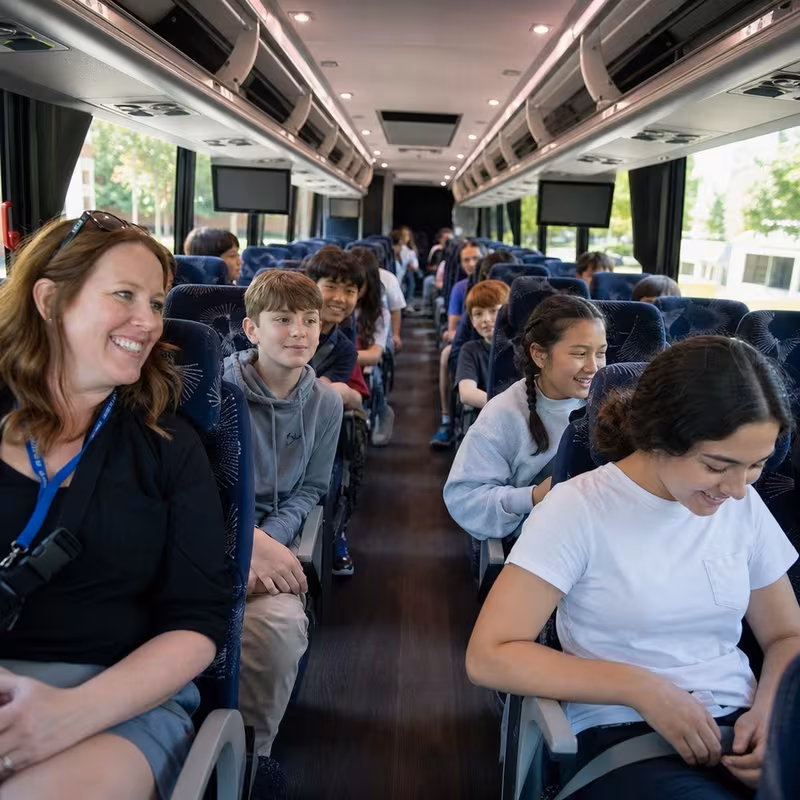 Group boarding a white charter bus for School Transportation transportation in Pittsburgh